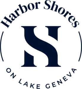 A green and black logo for harbor shores on lake geneva.