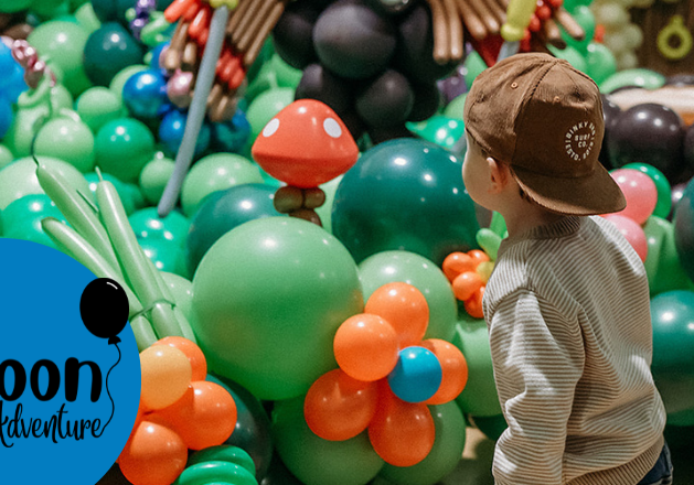 A child standing in front of balloons.